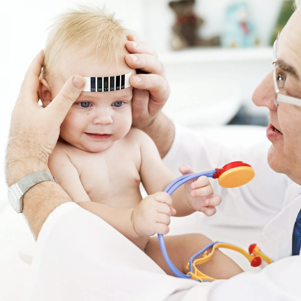 Doctor Applying a Thermometer to a Baby's (12-18) Forehead --- Image by © Royalty-Free/Corbis